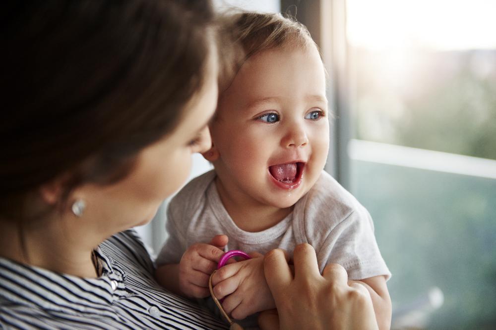 A mother holding her smiling baby